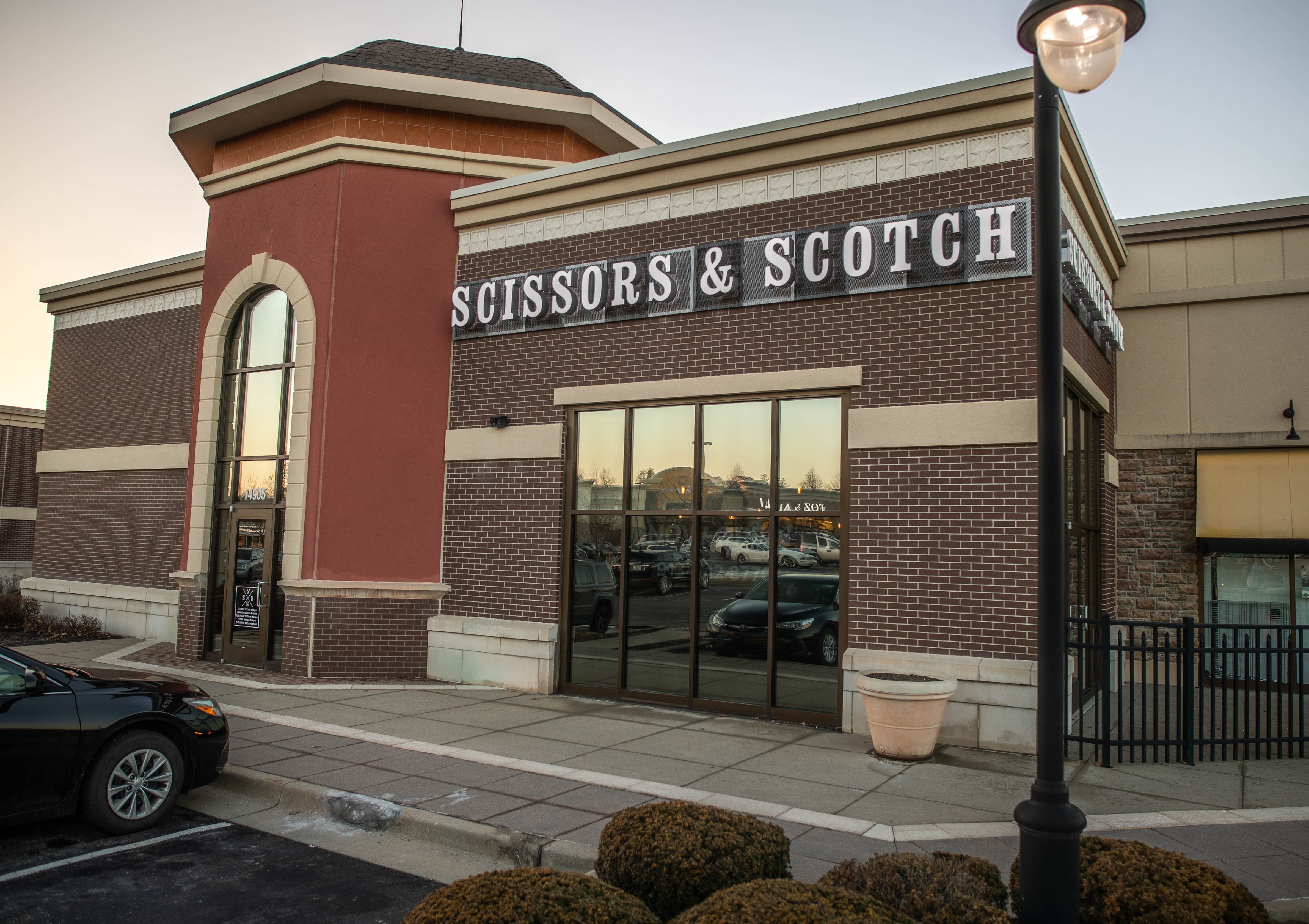 Scissors & Scotch lettering above the brick shop entrance